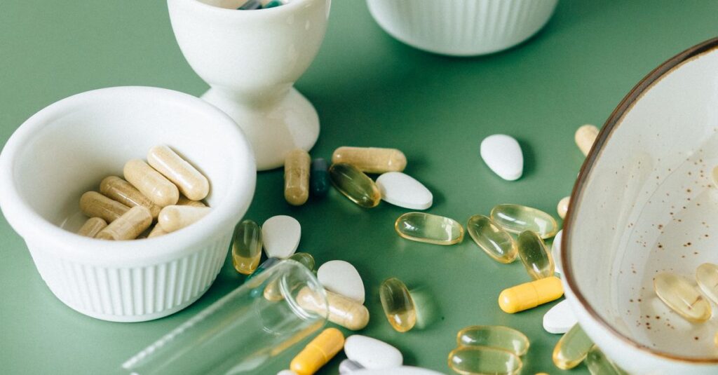 Assorted natural supplements and pills in ceramic bowls on a green background, showcasing health and wellness themes.