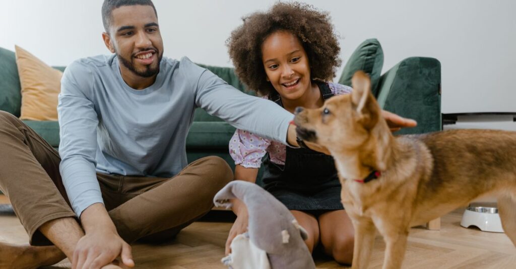 Man and girl enjoying quality time with their dog indoors, promoting family bonding.